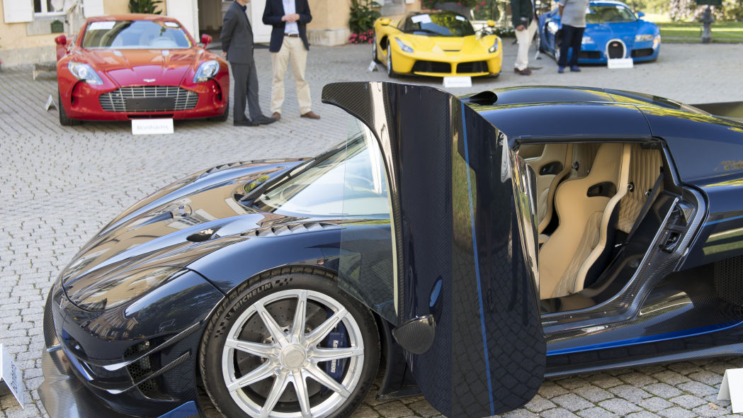 People looking at luxury cars owned by Teodoro Obiang, son of Equatorial Guinea's President Teodoro Obiang Nguema Mbasogo, before an auction of sales house Bonhams at the Bonmont Abbey Golf & Country Club near Geneva, Switzerland, September 29, 2019.