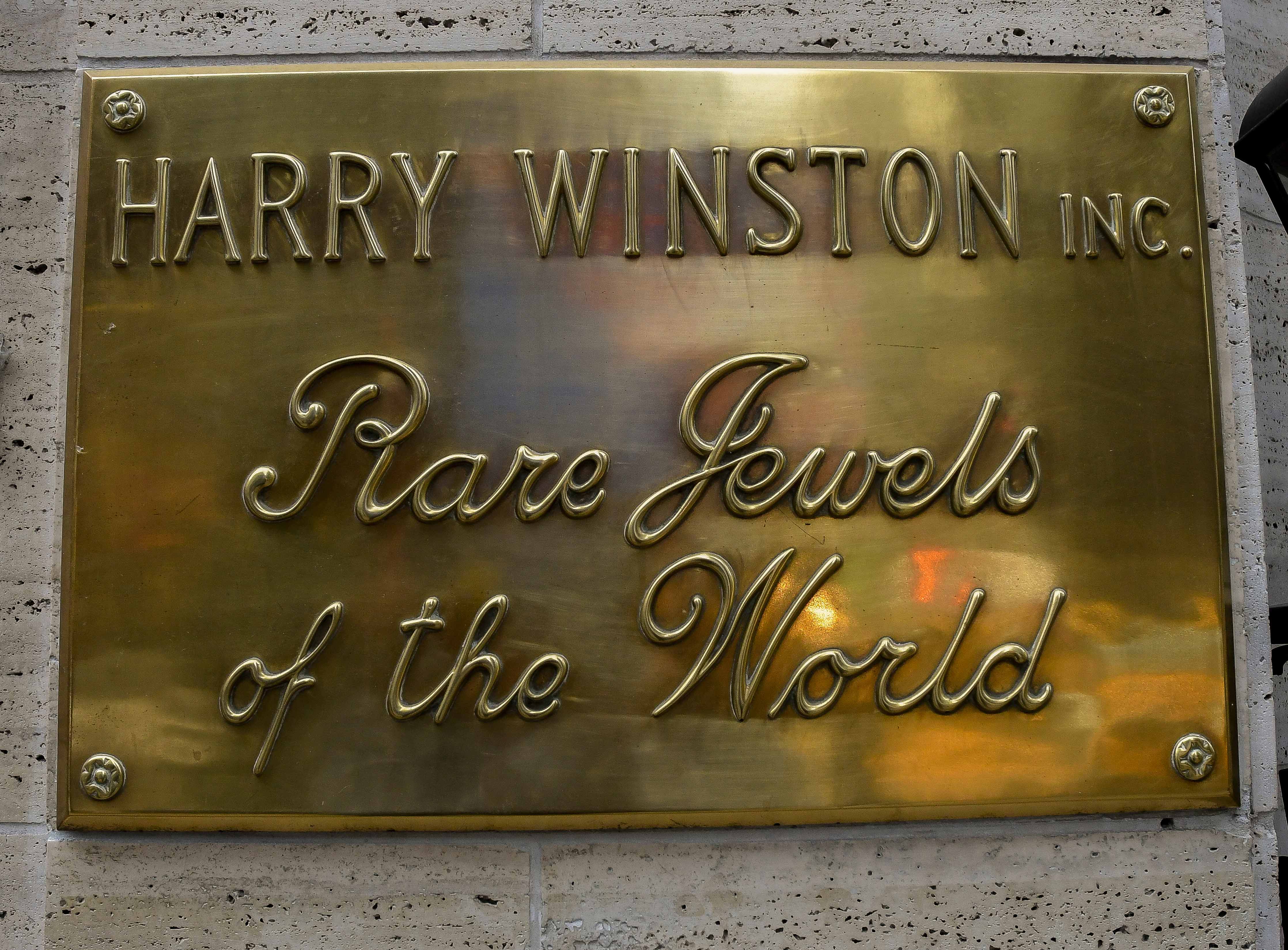 A gold plaque that reads "Harry Winston Inc.: Rare Jewels of the World"