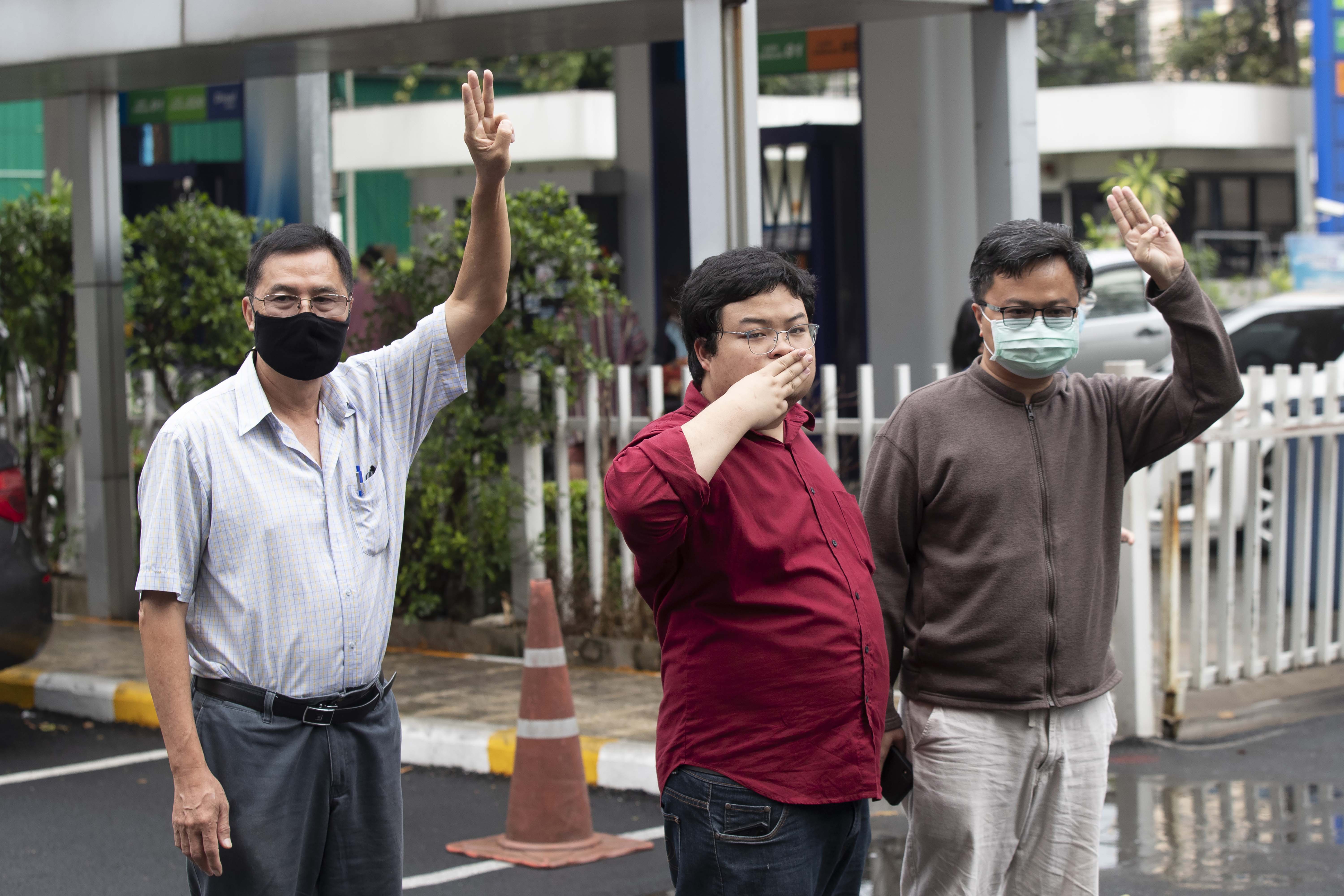 Activist Somyot Pruksakasemsuk, left Parit Chiwarak, and Arnon Nampha raise a three-finger salute, a symbol of resistance, as they arrive at Criminal court in Bangkok, Thailand, Tuesday, Feb. 9, 2021.