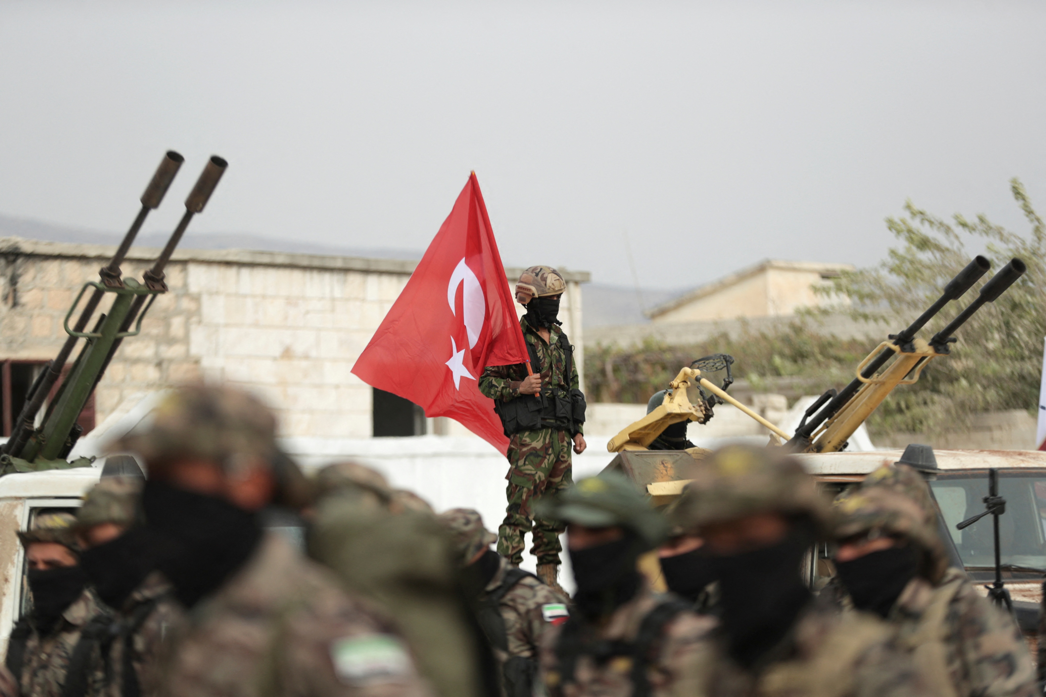 Ein nicht identifizierbarer Soldat hält eine türkische Flagge
