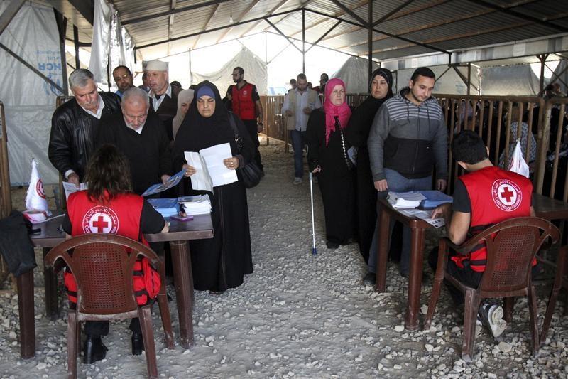 叙利亚难民在黎巴嫩北部特利波里排队领取联合国难民署（UNHCR）发放的冬季救济物资，2015年11月18日。