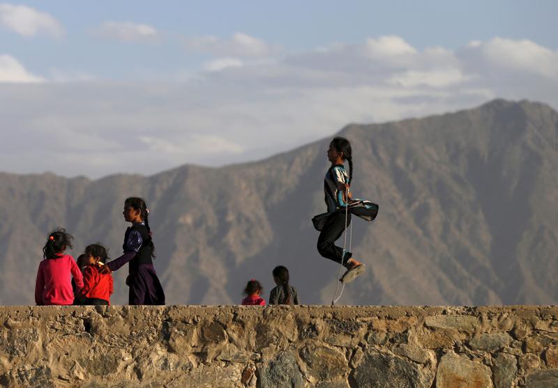 An Afghan girl (R) jumps rope on a hilltop in Kabul, Afghanistan May 18, 2015.