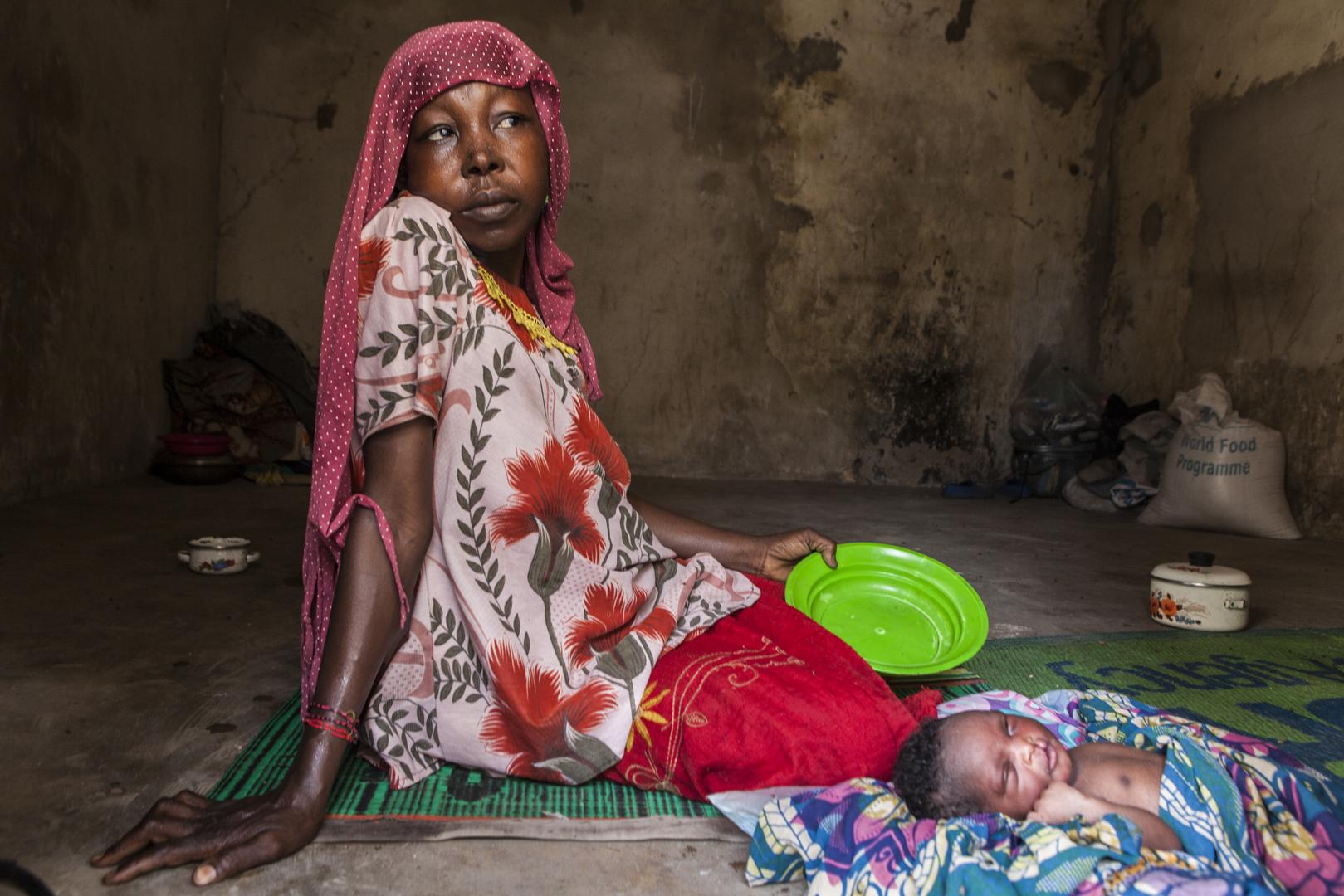After returning from Cameroon, a Nigerian woman sits with her new-born in the militarized displaced persons camp in Banki, northeast Nigeria, where a Boko Haram attack in early September killed 18 civilians.
