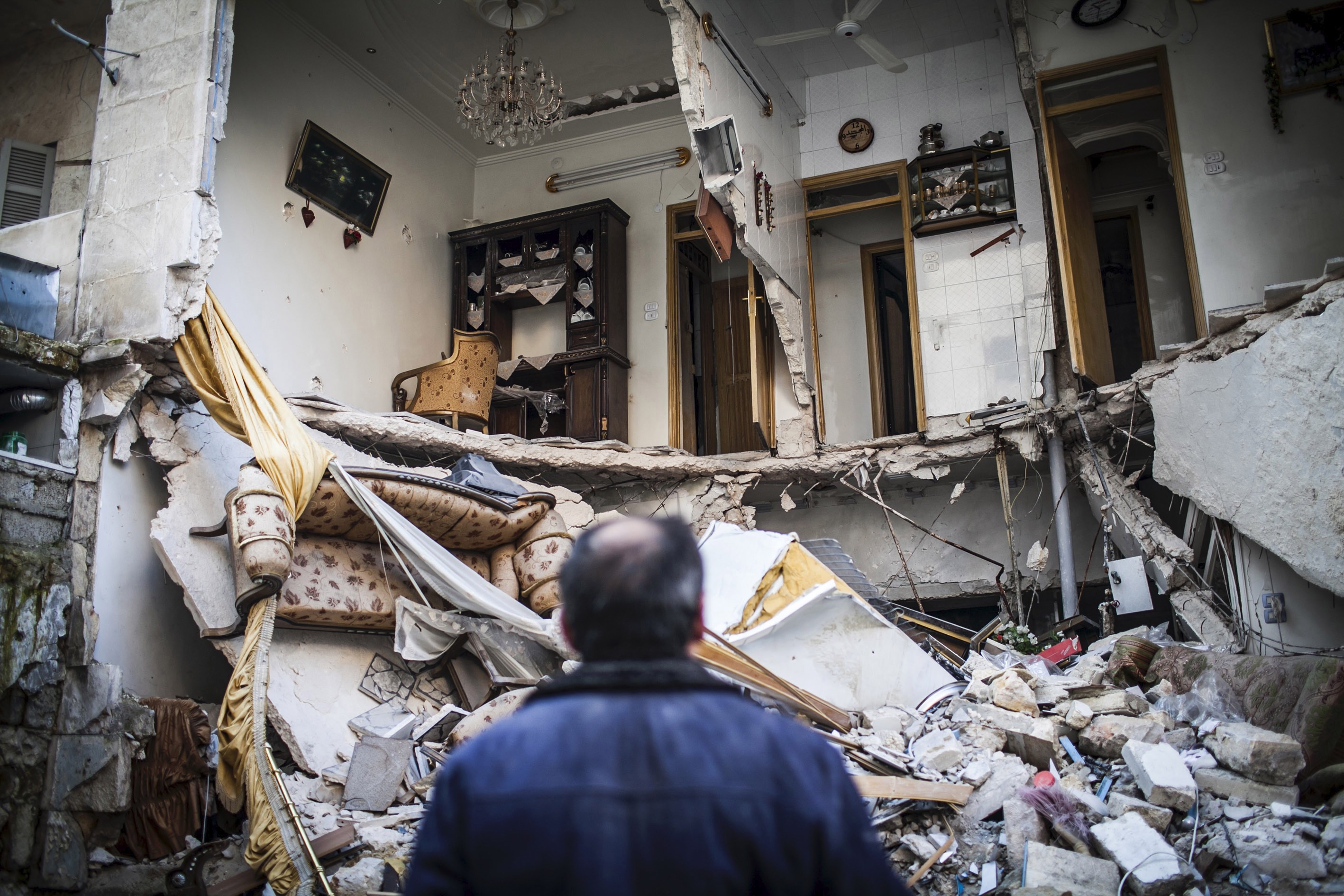 مدني ينظر إلى منزل مدمّر في حلب، سوريا، في 3 يناير/كانون الثاني 2013.