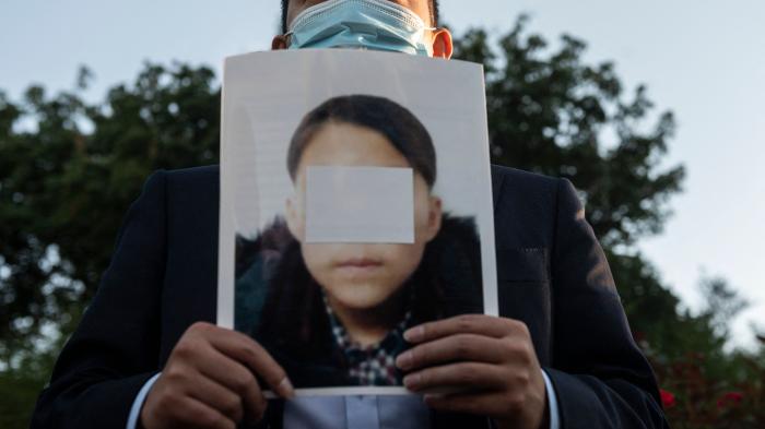 An activist holds a picture of an alleged young North Korean refugee during a demonstration calling on Chinese President Xi Jinping to allow safe passage to North Koreans detained in China, across the street from the Chinese embassy in Washington, DC, September 24, 2021. 