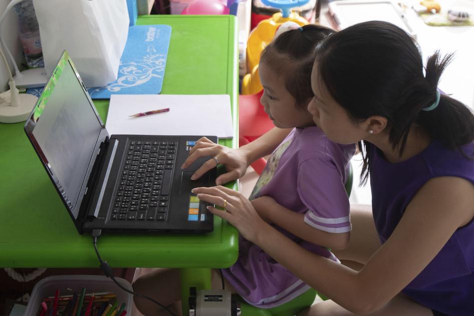 Cette jeune mère thaïlandaise aidait sa fille à suivre un cours en ligne sur son ordinateur portable, au domicile de la famille à Nonthaburi, en Thaïlande, en mai 2020. La plupart des écoles en Thaïlande étaient alors fermées, en raison du Covid-19.
