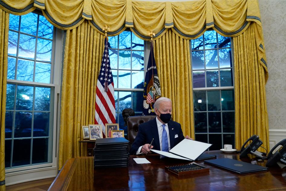 President Joe Biden signs his first executive orders in the Oval Office of the White House in Washington, January 20, 2021. 