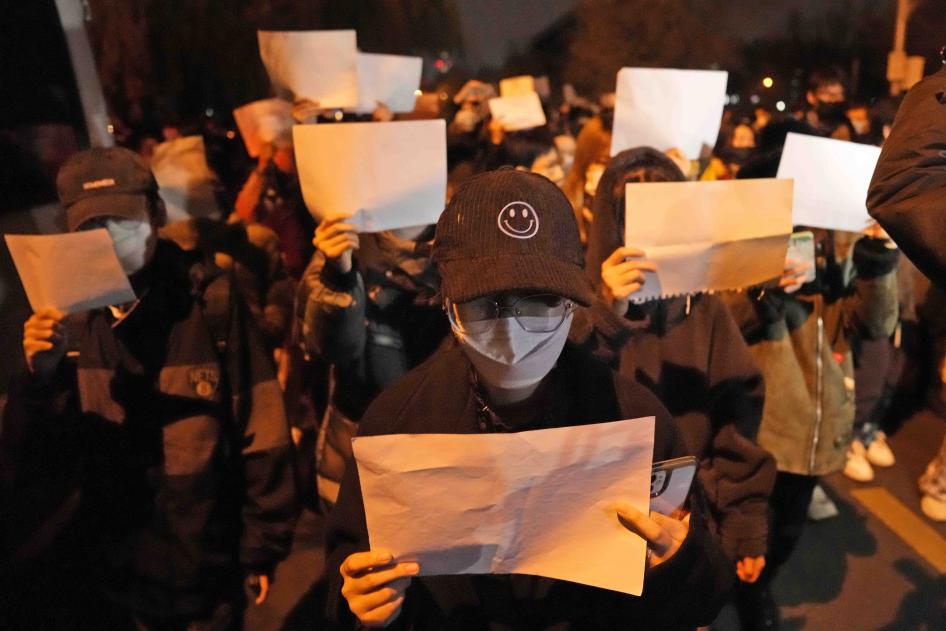 Des manifestants brandissent des feuilles blanches et scandent des slogans lors d'une marche de protestation à Pékin.