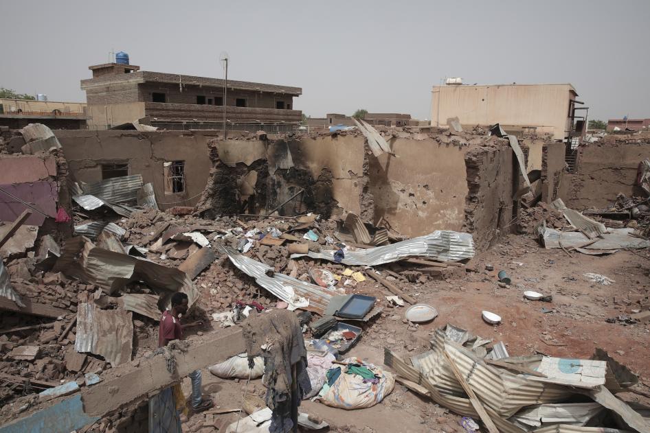 A man walks by a house hit in recent fighting in Khartoum, Sudan.