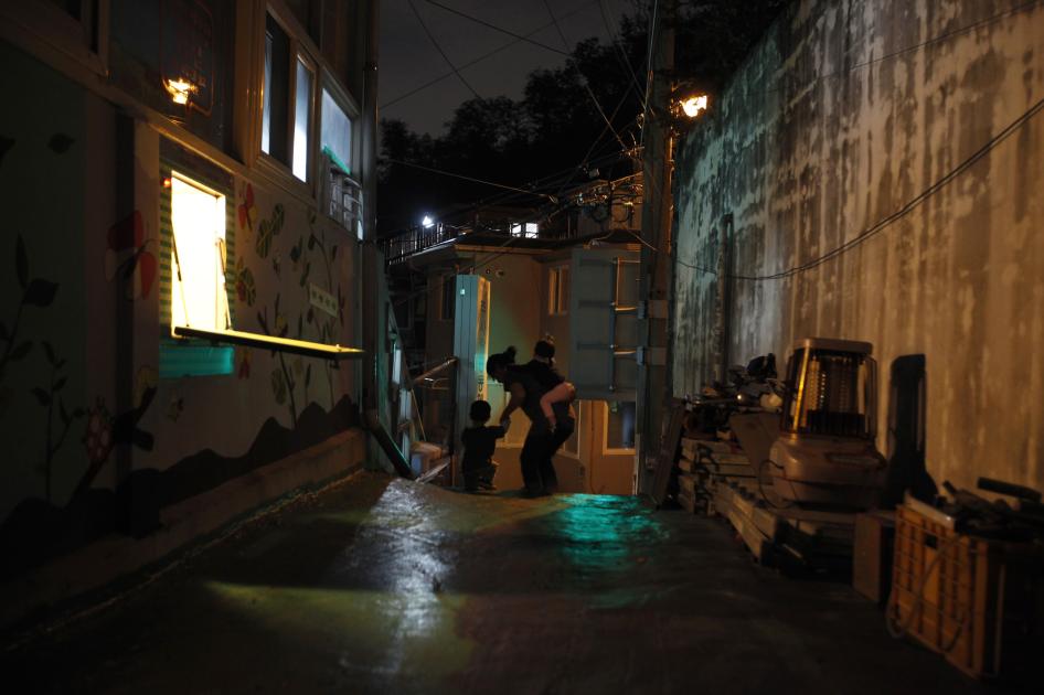 A “baby box,” where mothers can leave unwanted children, is visible on the left at Joosarang church as a preacher and two children go for a walk in Seoul, South Korea, September 20, 2012.