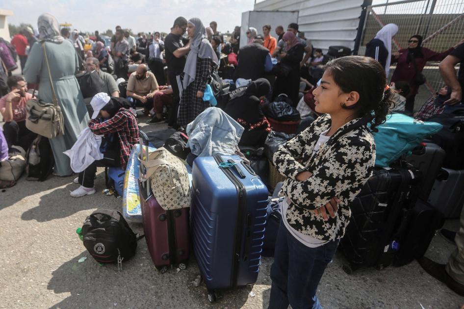 فلسطينيون، بعضهم يحمل جواز سفر أجنبي، ينتظرون المساعدات والعبور المحتمل إلى مصر، عند معبر رفح الحدودي جنوب قطاع غزة.