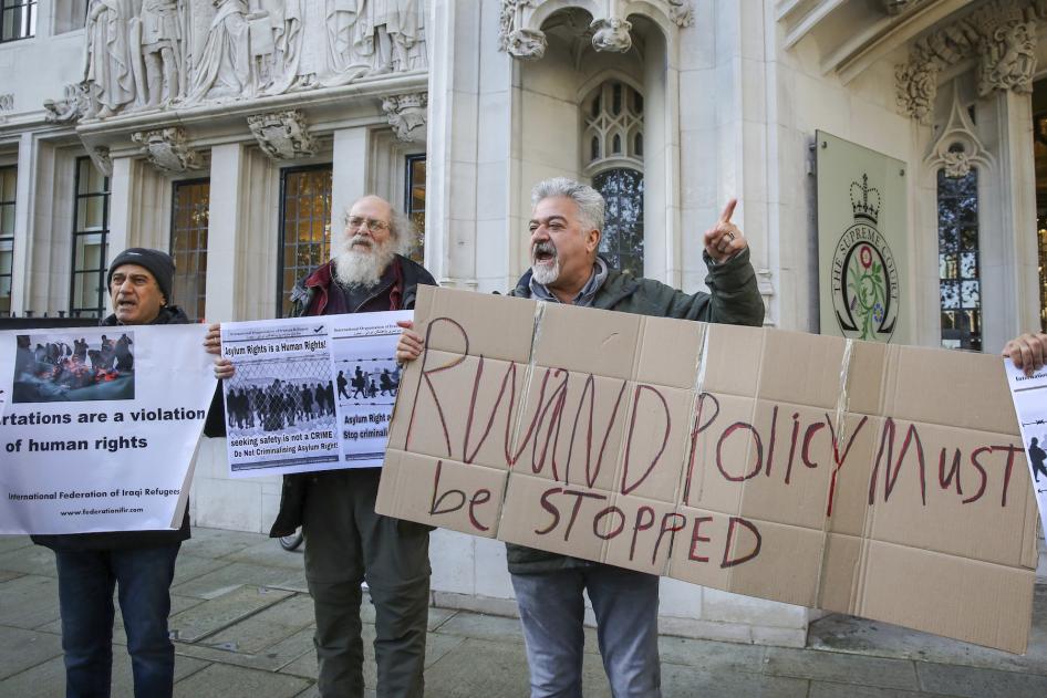 Demonstrierende halten Plakate vor dem Obersten Gerichtshof des Vereinigten Königreichs, als dieser entscheidet, dass der Asylplan der britischen Regierung für Ruanda rechtswidrig ist, London, Vereinigtes Königreich, 15. November 2023.