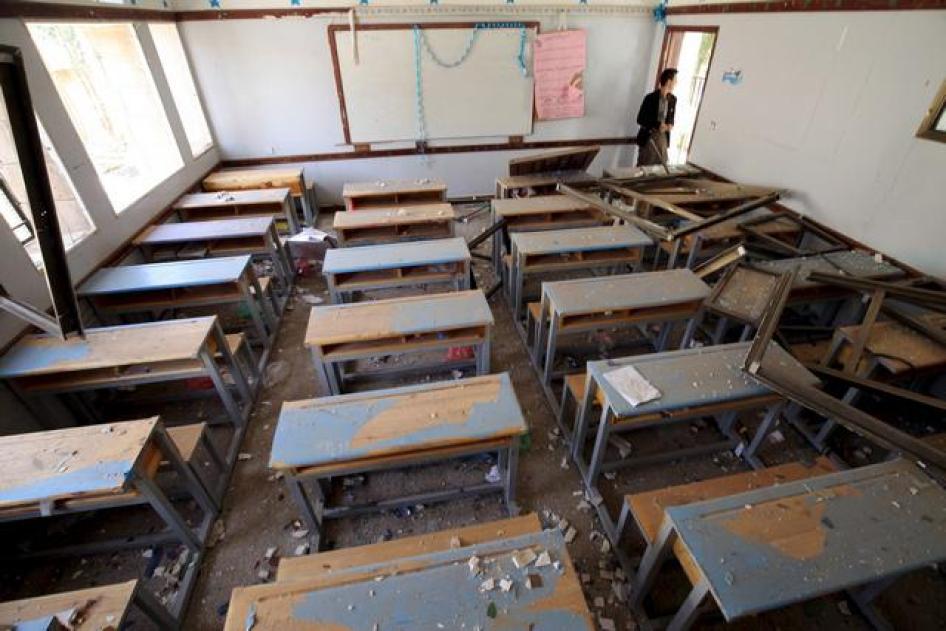 A man looks at a damaged classroom in a school after an air strike in Sanaa April 28, 2015. 