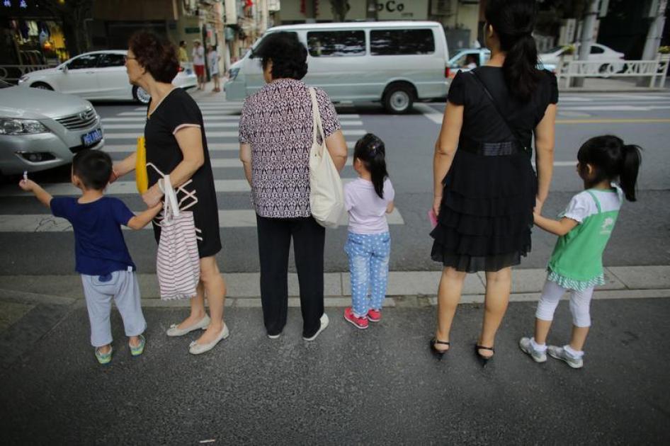Trois femmes chinoises tiennent les mains de leurs enfants près de leur école, dans le centre-ville de Shanghai, ke 12 septembre 2014.