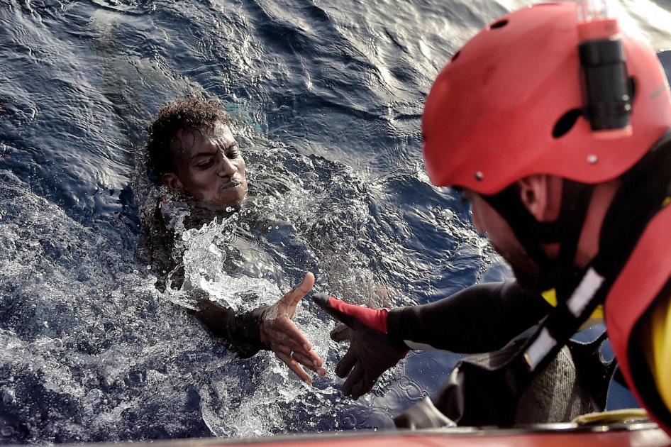 إنقاذ مهاجر في عرض البحر الأبيض المتوسط من قبل أحد عناصر منظمة "بروأكتيفا أوبن أرمز" غير الحكومية، على بعد نحو 20 ميلا بحريا شمال ليبيا، في 3 أكتوبر/تشرين الأول 2016. 
