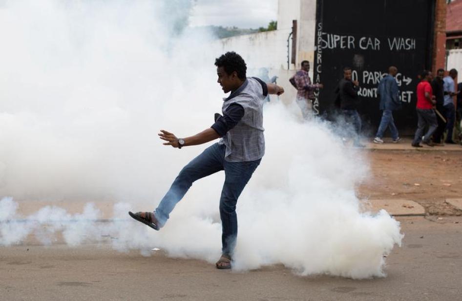 比勒陀尼亚本周发生暴民抢劫移民商铺后，警方强制驱散数以百计对立示威群众，一名男子试图将警方发射的催泪弹踢开，南非，2017年2月24日。