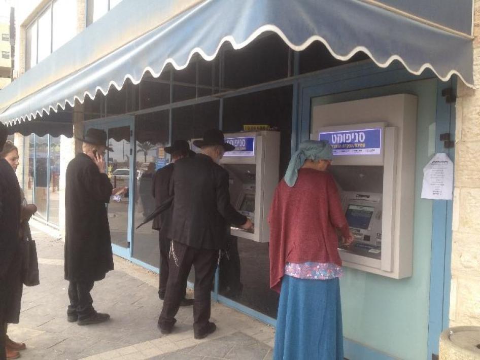 Des clients utilisent un distributeur à l’extérieur d’une agence bancaire dans la colonie israélienne de Modi'in Ilit, en Cisjordanie.