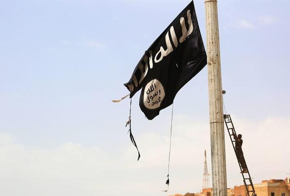 Un combattant des Forces démocratiques syriennes s'apprête à retirer un drapeau noir de l'État islamique dans la ville de Tabqa, à l'ouest de Raqqa en Syrie, le 30 avril 2017.