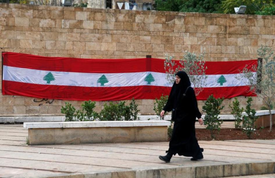 امرأة تمر أمام علم لبنان في بيروت، لبنان، 21 نوفمبر/تشرين الثاني 2017. © 2017 رويترز