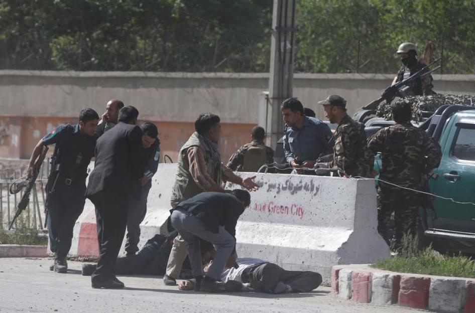 Policemen help Afghan journalists, victims of a second blast, in Kabul, Afghanistan April 30, 2018.