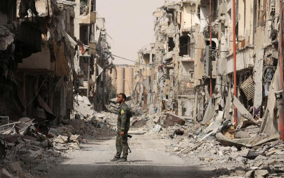 مقاتل من "قوات سوريا الديمقراطية" يقف على أنقاض مبان مدمّرة في الرقة، سوريا، 25 سبتمبر/أيلول 2017.  © 2017 رويترز/رودي سعيد