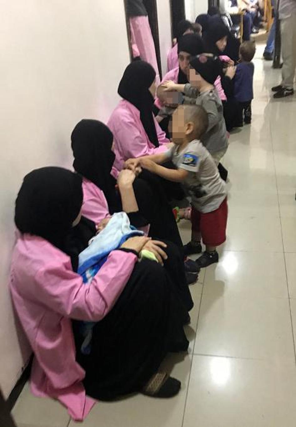 Des femmes russes, condamnées à la prison à vie pour appartenance à l'Etat islamique, assises par terre avec leurs enfants dans un couloir du Tribunal pénal central de Bagdad, le 29 avril 2018. © 2018 Ammar Karim/AFP/Getty Images