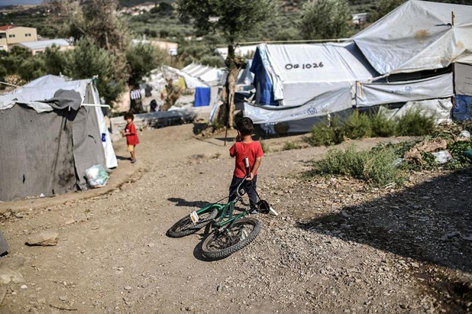 Ένα αγόρι κρατάει ένα ποδήλατο σε στρατόπεδο κοντά στο στρατόπεδο προσφύγων της Μόριας στο νησί της Λέσβου στις 5 Αυγούστου 2018.