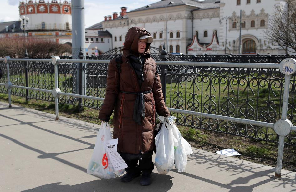 Бездомная женщина держит в руках пакеты с продуктами питания и предметами гигиены, розданными благотворительной организацией "Ночлежка", в связи с Covid-19, Москва, Россия, апрель 2020 года.
