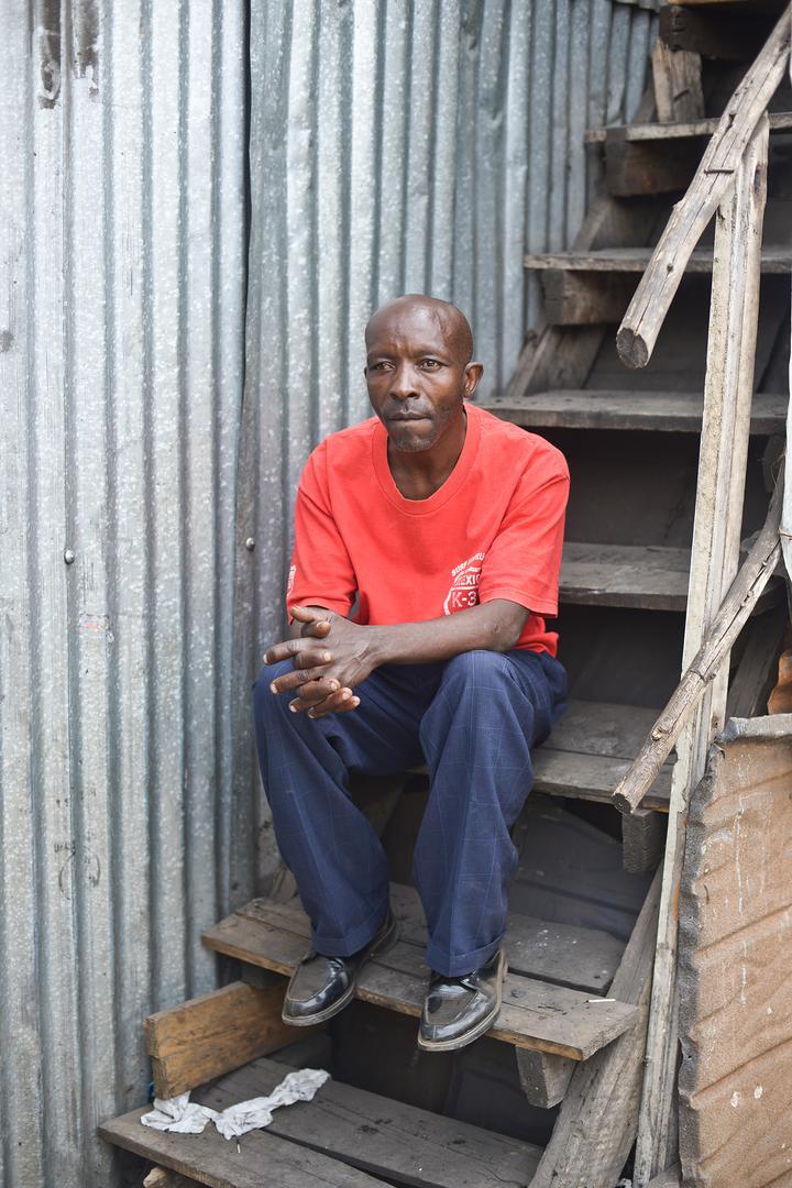 John K., 48 ans, assis sur les marches en bois d'une maison dans le bidonville de Kibera. La typologie des violences sexuelles commises au cours des violences post-électorales de 2007-2008 au Kenya comprend le viol à grande échelle de femmes et de jeunes 