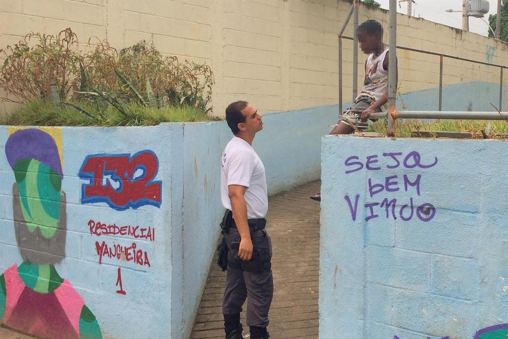 O policial militar Wallace Justo (esq.) fala com uma criança na favela da Mangueira em 14 de janeiro de 2016. 