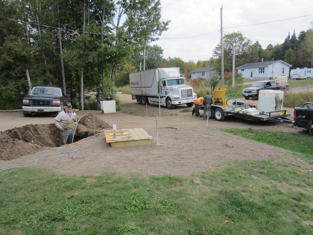 A contractor works to connect a household to a neighbor’s well in Batchewana First Nation. The household had been without water for over a year after its second well had run dry. 