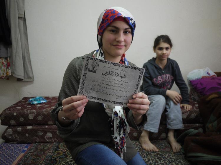 Rawan, 14 ans, tient le certificat qu’elle a reçu à la fin de sa classe de CM1 dans un centre d'éducation temporaire syrien à Istanbul. Elle a manqué près de de quatre années d’école avant son inscription en janvier 2015.