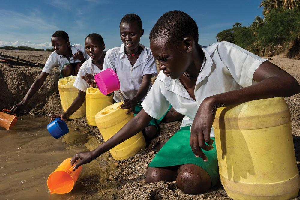 Les jeunes filles de l’école primaire pour filles de Kalokol vont chercher de l’eau dans un lit de cours d’eau asséché ; elles ramènent ensuite l’eau vers leur école dépourvue d’accès à l’eau courante.