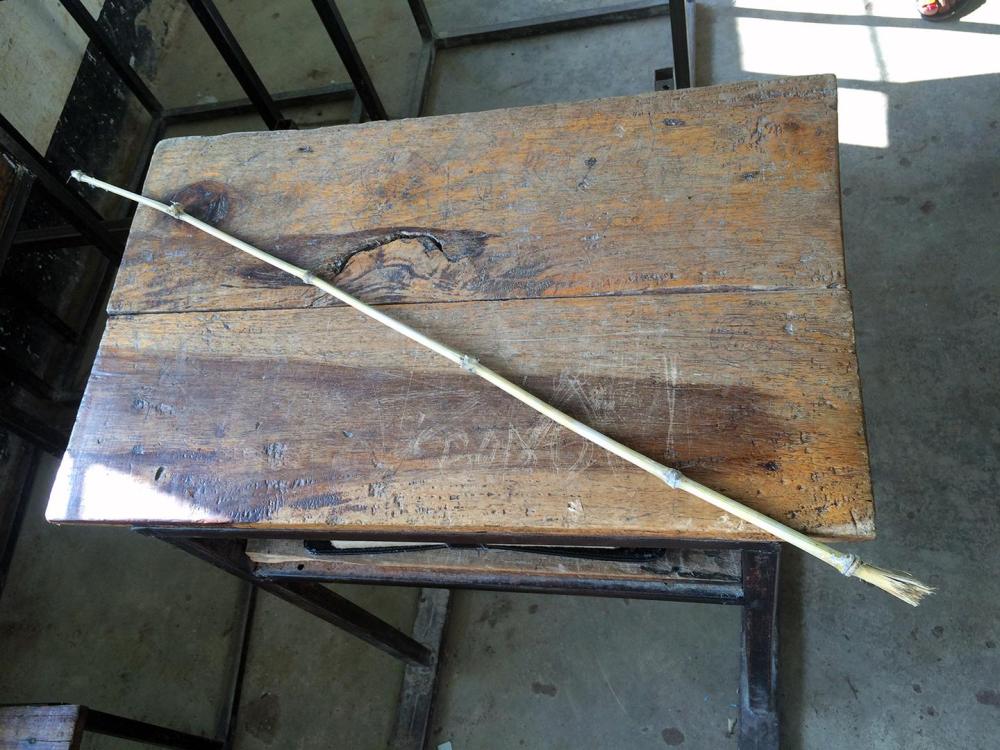 A bamboo cane used by a teacher to cane students in a classroom lies on a desk at a secondary school in Mwanza, northwestern Tanzania. 