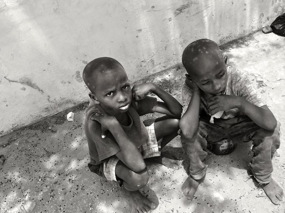 Deux talibés, âgés de 7 et 8 ans, se reposent brièvement après avoir mendié à Dakar, au Sénégal. Le plus jeune des deux avait une blessure infectée à la jambe, qui n’avait pas été soignée. 12 mai 2017.  