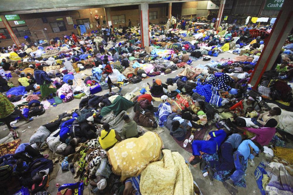 Des cultivateurs de tabac dorment dans une maison de vente aux enchères à Harare, au Zimbabwe, en attendant de vendre le tabac récolté.