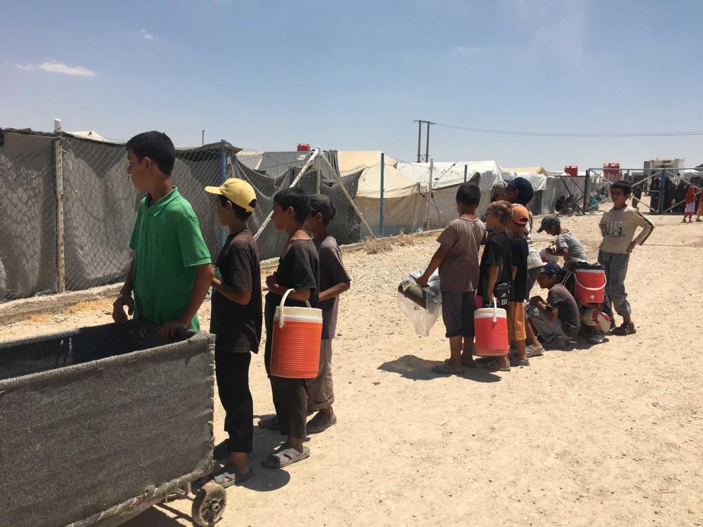 Дети, находящиеся в спецзоне лагеря ‘Аль-Холь’, выстроились в очередь, чтобы получить разрешение на получение пайков из основной части лагеря.