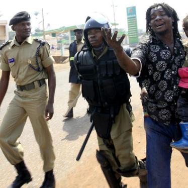 Police arrest a man with a child in a suburb of Kampala on September 11, 2009.