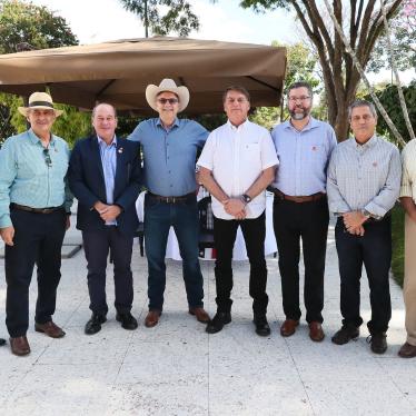 Brazil´s President Jair Bolsonaro (center, wearing a white shirt) poses for a picture with US Ambassador Todd Chapman (center, wearing a hat) and several ministers during a luncheon at the ambassador´s residence, July 4, 2020.