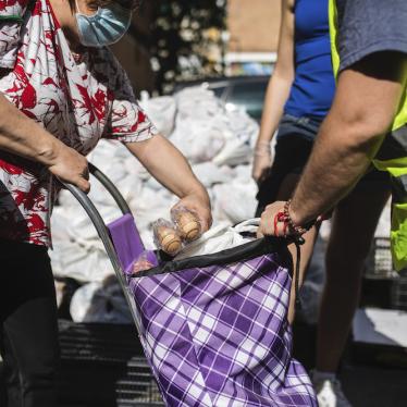 A woman receives donated food from the Aluche Neighborhood Association headquarters where volunteers have delivered food and donated products for those in need amid coronavirus outbreak, in Madrid, Spain.