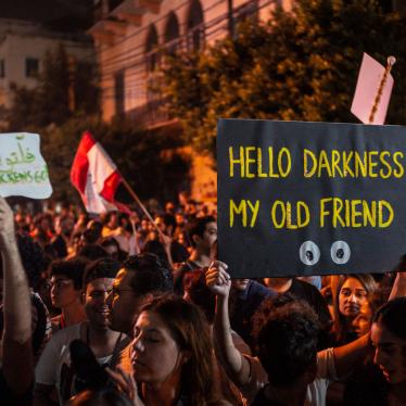 A protester holds up a placard reading, “Hello Darkness My Old Friend,” in front of the Lebanese electricity company headquarters, during protests against the Lebanese government and corruption, in Beirut, Lebanon, November 7, 2019.