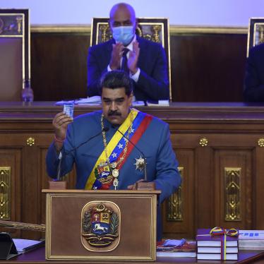 Venezuela's Nicolás Maduro holds a copy of the constitution during his annual address to the nation before lawmakers at the National Assembly in Caracas, Venezuela, Tuesday, Jan. 12, 2021.