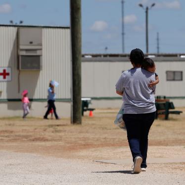 A woman walks carrying her child at the US Immigration and Customs Enforcement (ICE) South Texas Family Residential Center, in Dilley, Texas, August 23, 2019. 