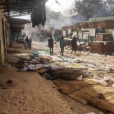 People walk among scattered objects in the market of El Geneina, the capital of West Darfur, after fighting between Sudan's army and the Rapid Support Forces.