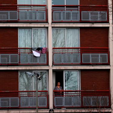 A woman stands in the doorway of an apartment block 