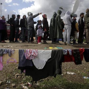 Refugees and migrants line up to receive aid in a makeshift camp at the Greek-Macedonian border, near the Greek village of Idomeni March 4, 2016. 