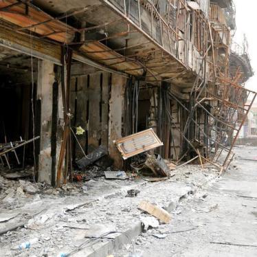 A girl walks past the site after a suicide car bomb attack at the shopping area of Karrada, a largely Shi'ite district, in Baghdad, Iraq July 4, 2016. 