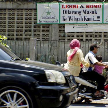 People drive a motorcycle past a banner put up by the hardline Islamic Defenders Front calling for gay people to leave the Cigondewah Kaler area in Bandung, Indonesia West Java province, January 27, 2016 in this photo taken by Antara Foto. The banner read