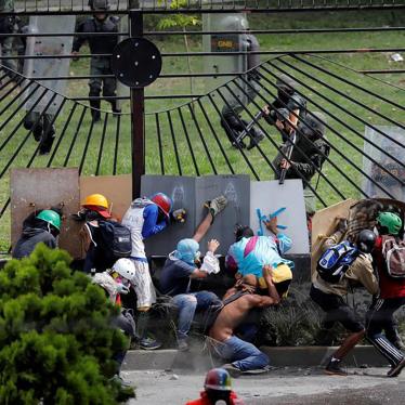 Manifestantes se enfrentan a fuerzas de seguridad antidisturbios en la reja de una base aérea durante una manifestación contra el Presidente Nicolás Maduro en Caracas, Venezuela.