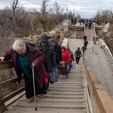 Older people crossing the broken bridge at the Stanytsia Luhanska checkpoint.